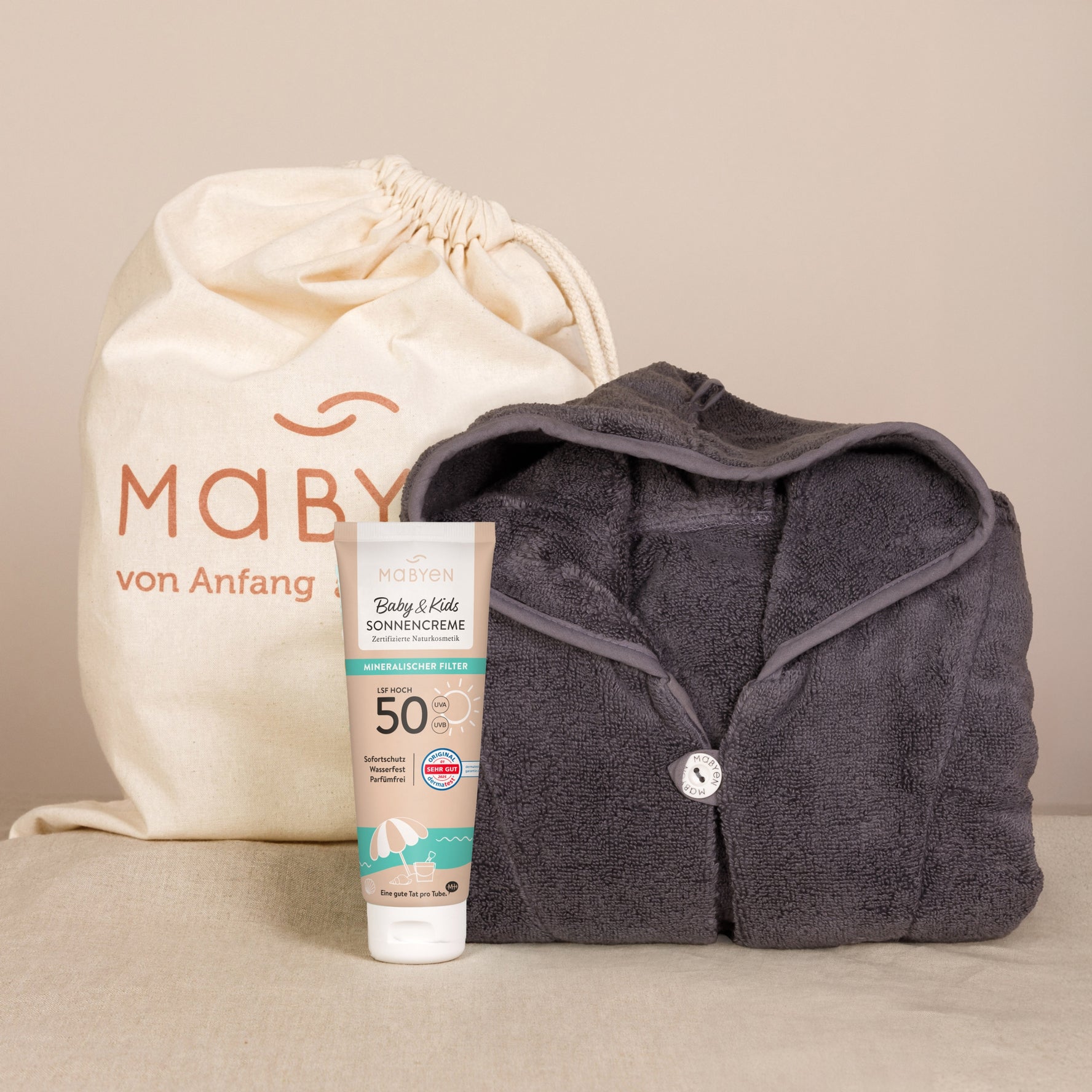 Sonnencreme und Poncho dunkelgrau
