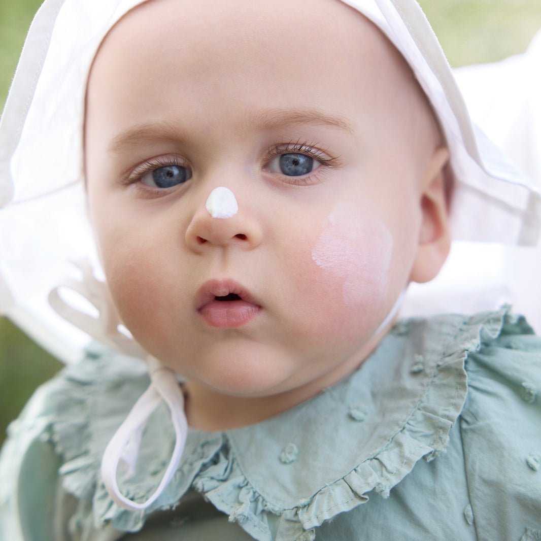 Baby mit Sonnencreme auf der Nase