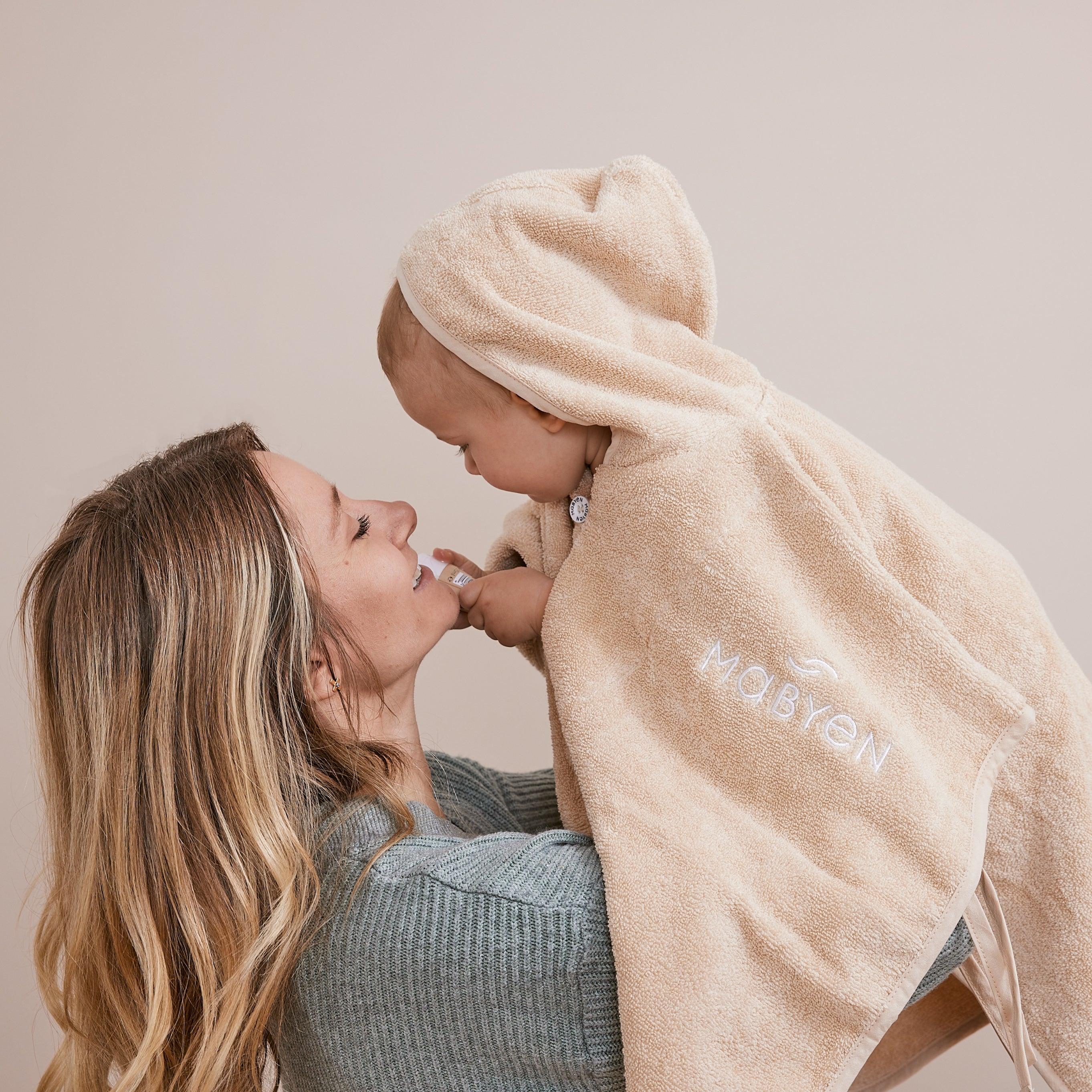 Mama und Baby im beigen Poncho